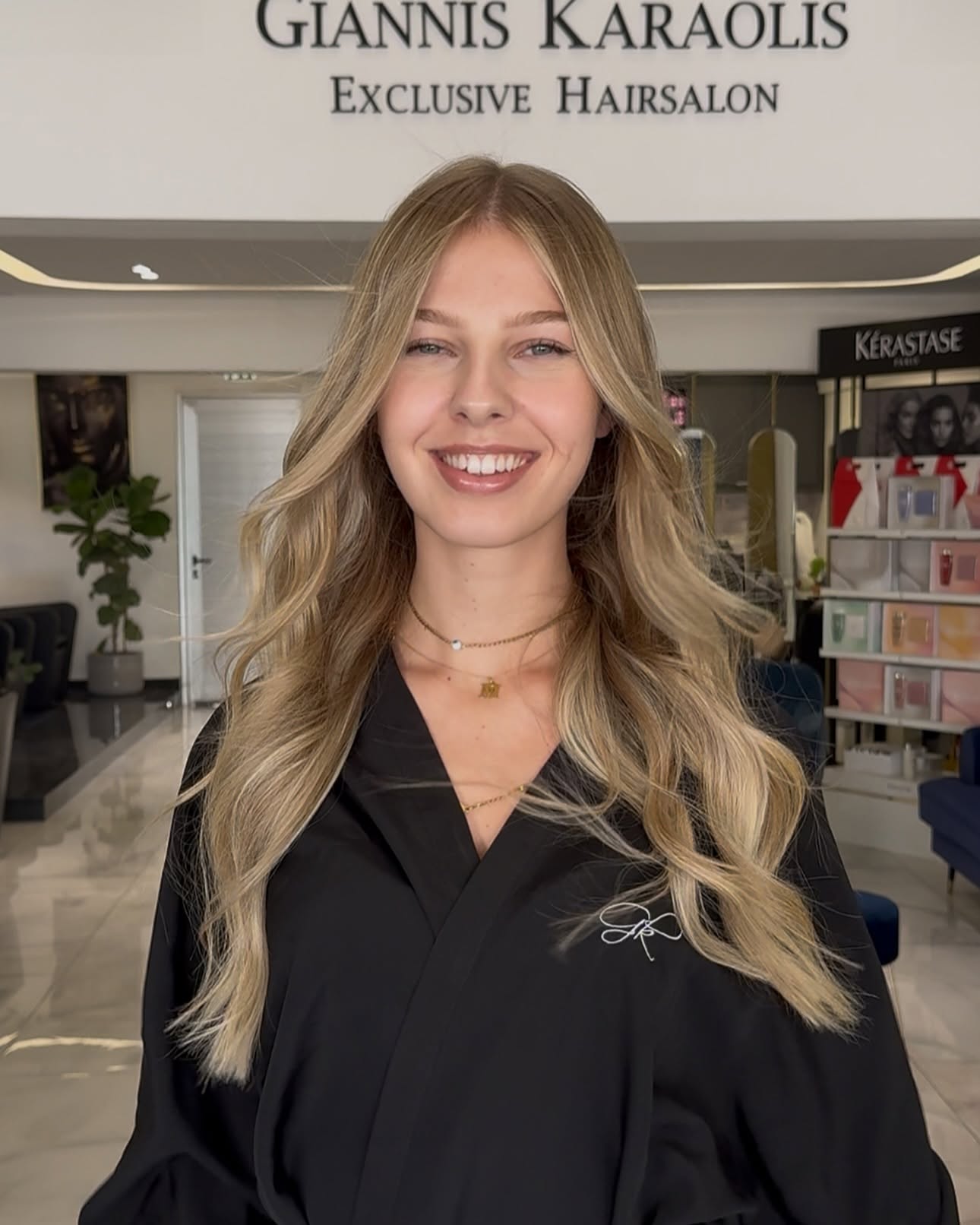 Client with soft blonde waves smiling inside Giannis Karaolis Exclusive Hairsalon in Paphos
