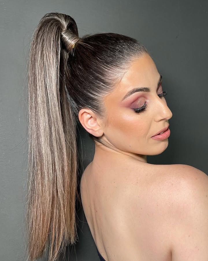 Sleek high ponytail with balayage highlights and soft plum eye makeup by Giannis Karaolis in Paphos